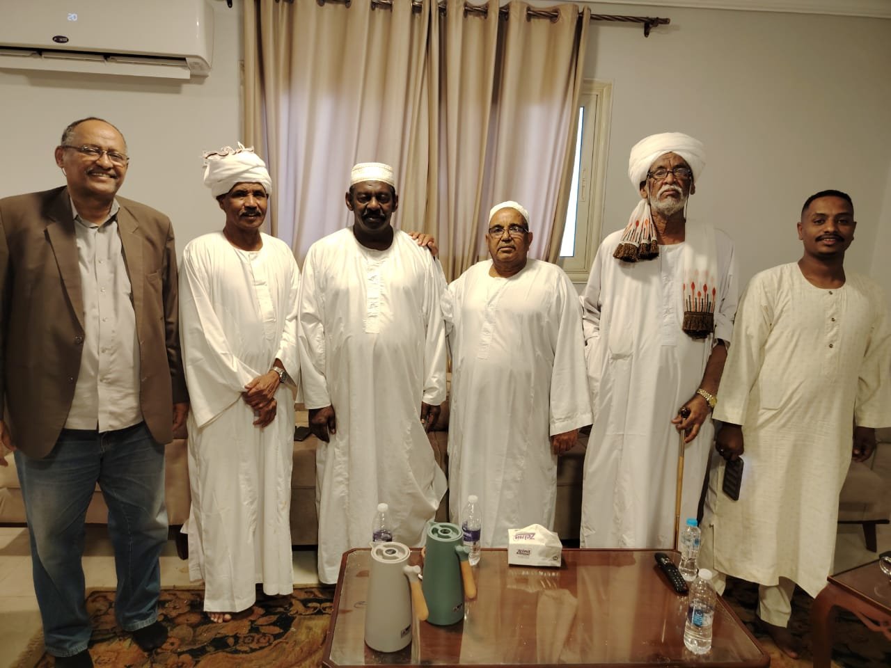 صورة توثّق لقاءً اجتماعياً جمع عدداً من رجال القانون والأعمال. ويظهر فيها من الشمال إلى اليمين: الأستاذ عبد الرحيم النصري المحامي، والمستشار الطيب مضوي شيقوق، ورجل الأعمال عصام الشيخ، وشيخ العرب ورجل الأعمال عبد الله فضل، والأستاذ كرار صديق المحامي، وأحد أفراد أسرة الأستاذ عصام الشيخ.